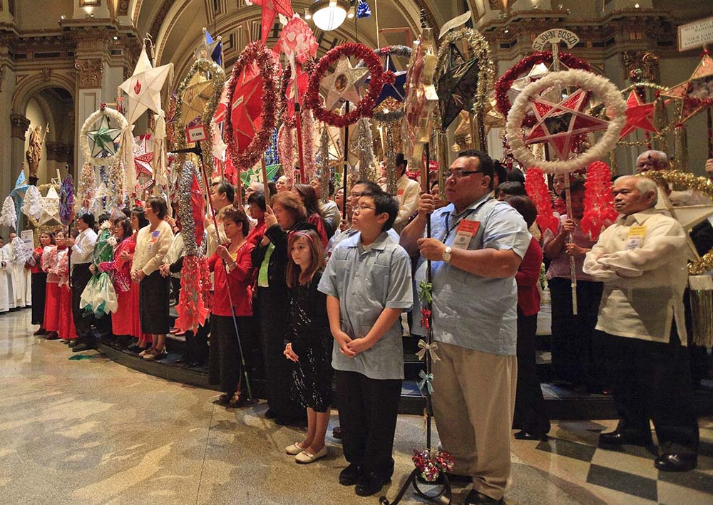 Catholics hold up parol, or Christmas lanterns, for blessing at St. James Cathedral in Seattle during Simbang Gabi celebrations in 2010. (CNS/Mike Penney)