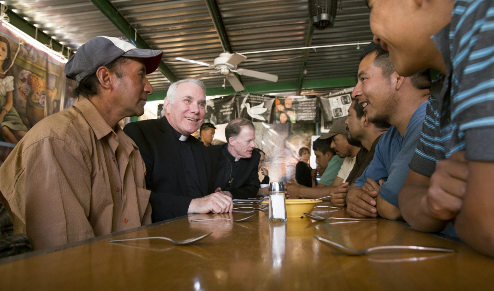 Fr. Clete Kiley (second from left), along with Salt Lake City Bishop John Wester, talks with men at the Aid Center for Deported Migrants in Nogales, Mexico, in 2014. (CNS/Nancy Wiechec)