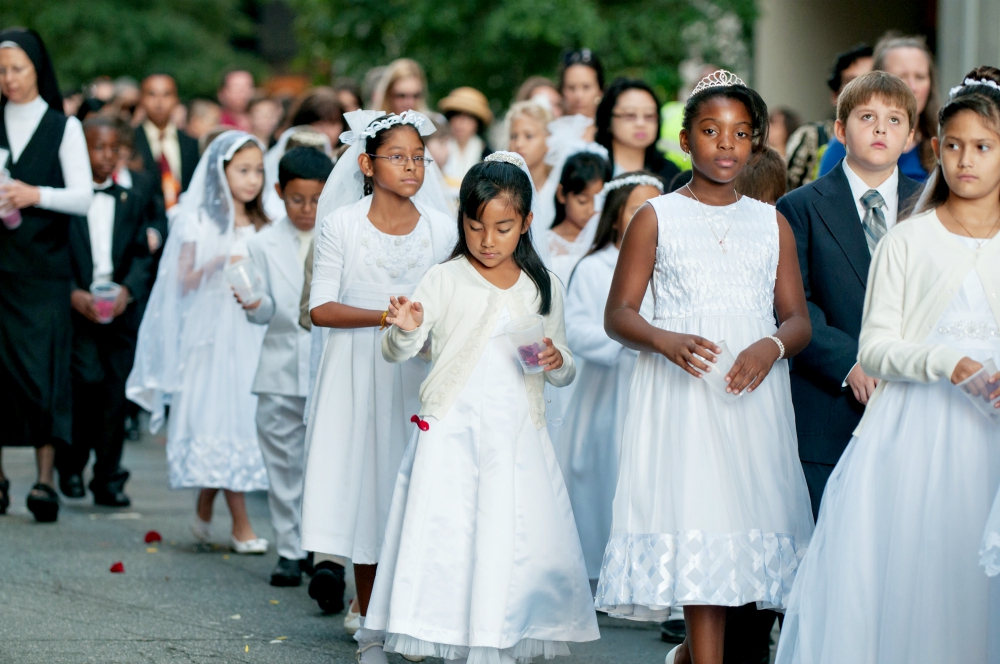 Children receiving first Communion scatter rose petals during a eucharistic procession through downtown Charlotte, North Carolina, in 2014. (CNS/Catholic News Herald/Bill Washington)