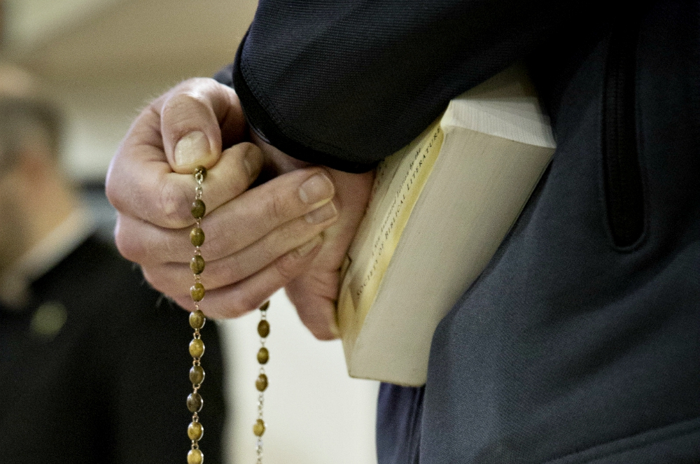 A seminarian from St. John's Seminary in Brighton, Massachusetts, holds a rosary before a discussion with a youth group in 2016. (CNS/Chaz Muth)