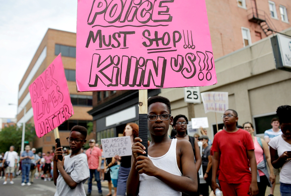 Young people hold signs during September 2017 protests after a not-guilty verdict in the murder trial of former St. Louis police officer Jason Stockley, charged with the 2011 fatal shooting of Anthony Lamar Smith, who was black. Stockley is white. (CNS)