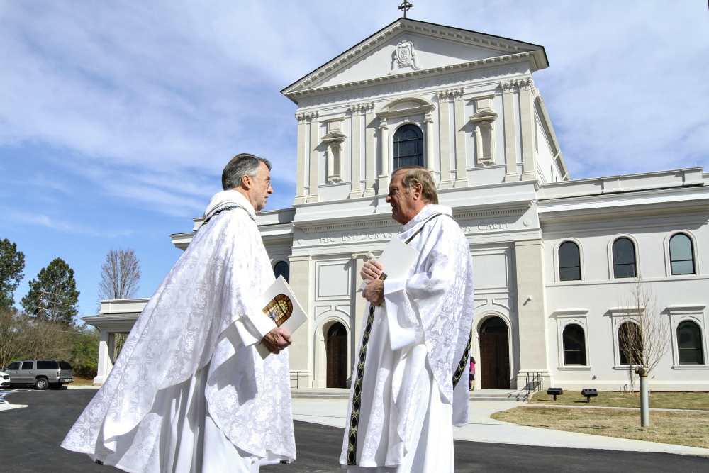 Fr. David Dye, retired administrator of Mary Our Queen Church in Peachtree Corners, Georgia, and Fr. Francis "Butch" Mazur, the last pastor of St. Gerard Church in Buffalo, New York, discuss the new Mary Our Queen Church in the background. (CNS)