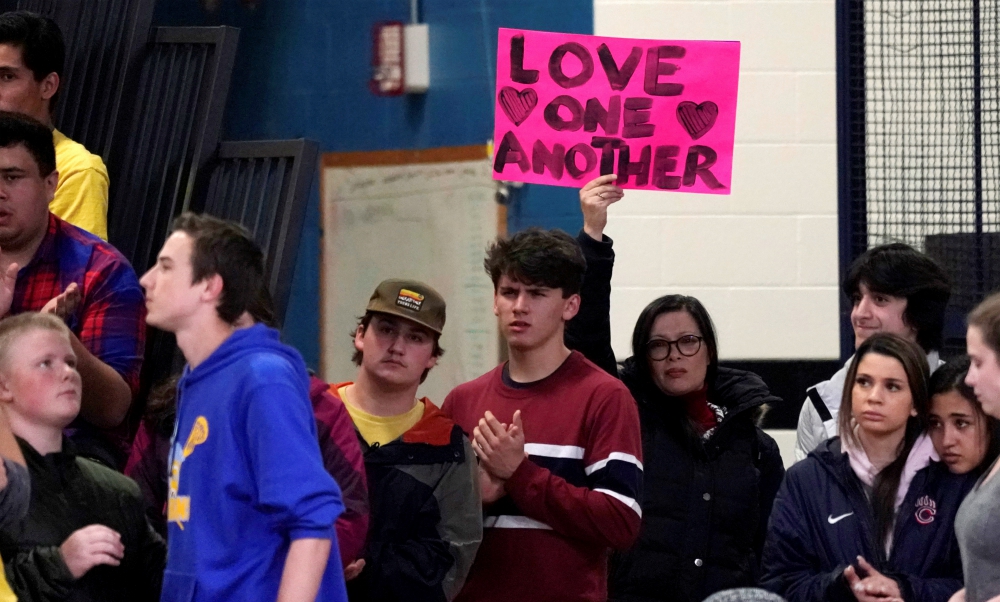 A woman displays a sign during a vigil May 8 for victims of a shooting the day before at the STEM School Highlands Ranch in Colorado. (CNS/Reuters/Rick Wilking)