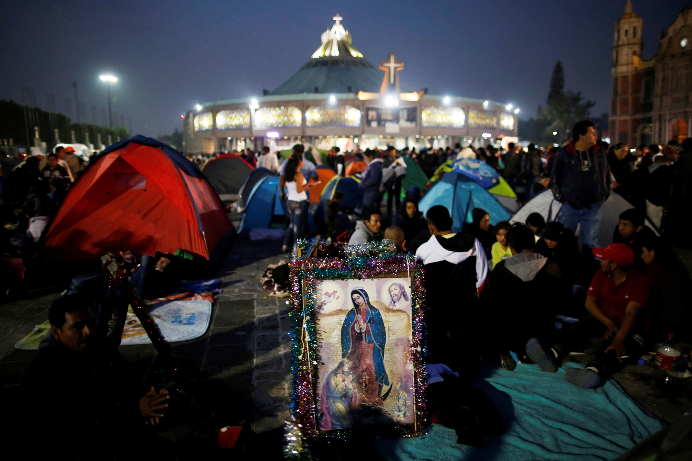 Pilgrims rest beside an image of Our Lady of Guadalupe Dec. 11, 2018, the eve of her feast day at the Basilica of Our Lady of Guadalupe in Mexico City. (CNS)