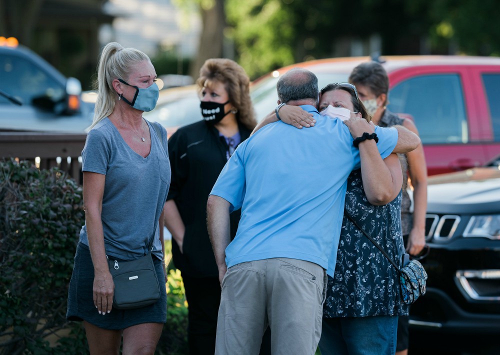 People attend a prayer vigil outside St. Joseph Catholic Church in Trenton, Michigan, Aug. 17, for Robert Chiles, a parishioner, and Fr. Stephen Rooney, St. Joseph's pastor, who disappeared in a boating accident on the Detroit River the previous day.