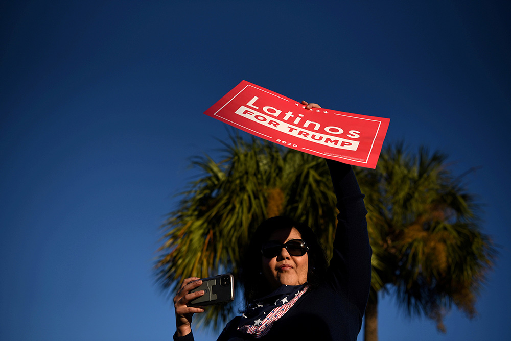 A Latina voter holds up a sign in support of President Donald Trump as voters line up at a polling station on Election Day in Houston Nov. 3. (CNS/Reuters/Callaghan O'Hare)