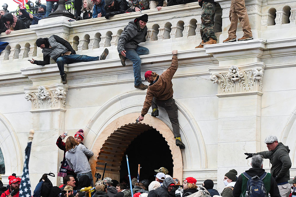 Supporters of President Donald Trump climb on walls at the U.S. Capitol in Washington Jan. 6. (CNS/Reuters/Stephanie Keith)