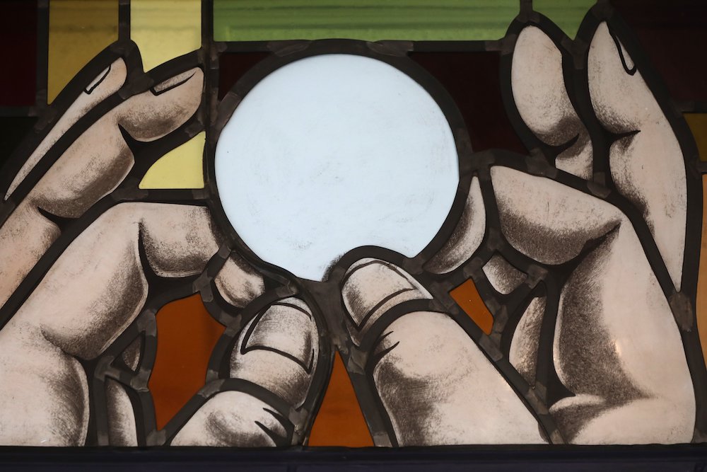 Elevation of the Eucharist is depicted in a stained-glass window at St. Anthony's Church July 15 in North Beach, Maryland. (CNS/Bob Roller)