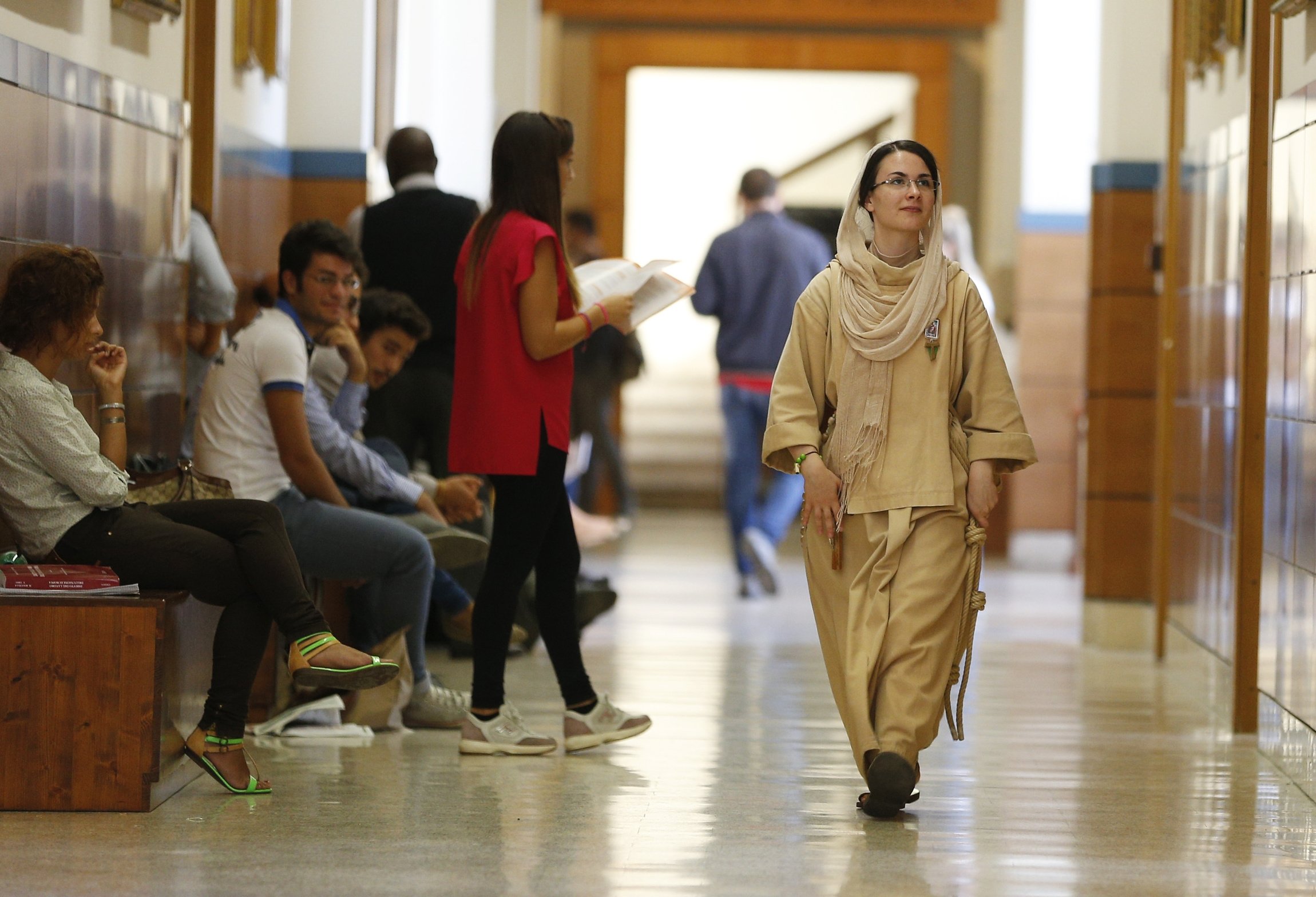 A member of a religious congregation walks down the hall as lay students wait between classes at the Pontifical Lateran University in Rome in this Sept. 20, 2013, file photo. The Vatican's Congregation for Catholic Education has released guidelines on the