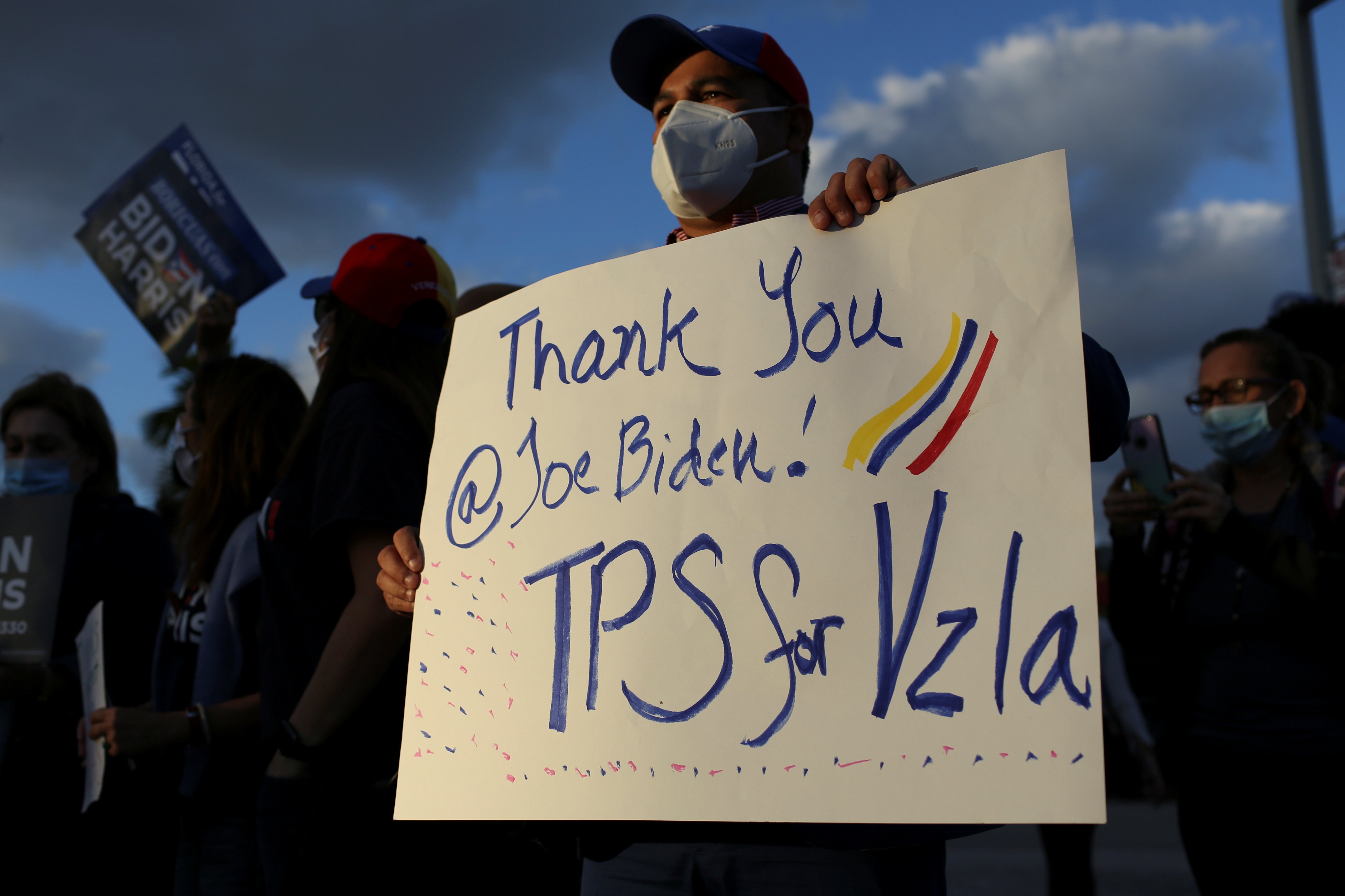 A man in Doral, Fla., holds a sign March 9, 2021, as members of the Venezuelan community react after the Biden administration said it would grant Temporary Protected Status to Venezuelan immigrants living in the United States. (CNS photo/Marco Bello, Reut