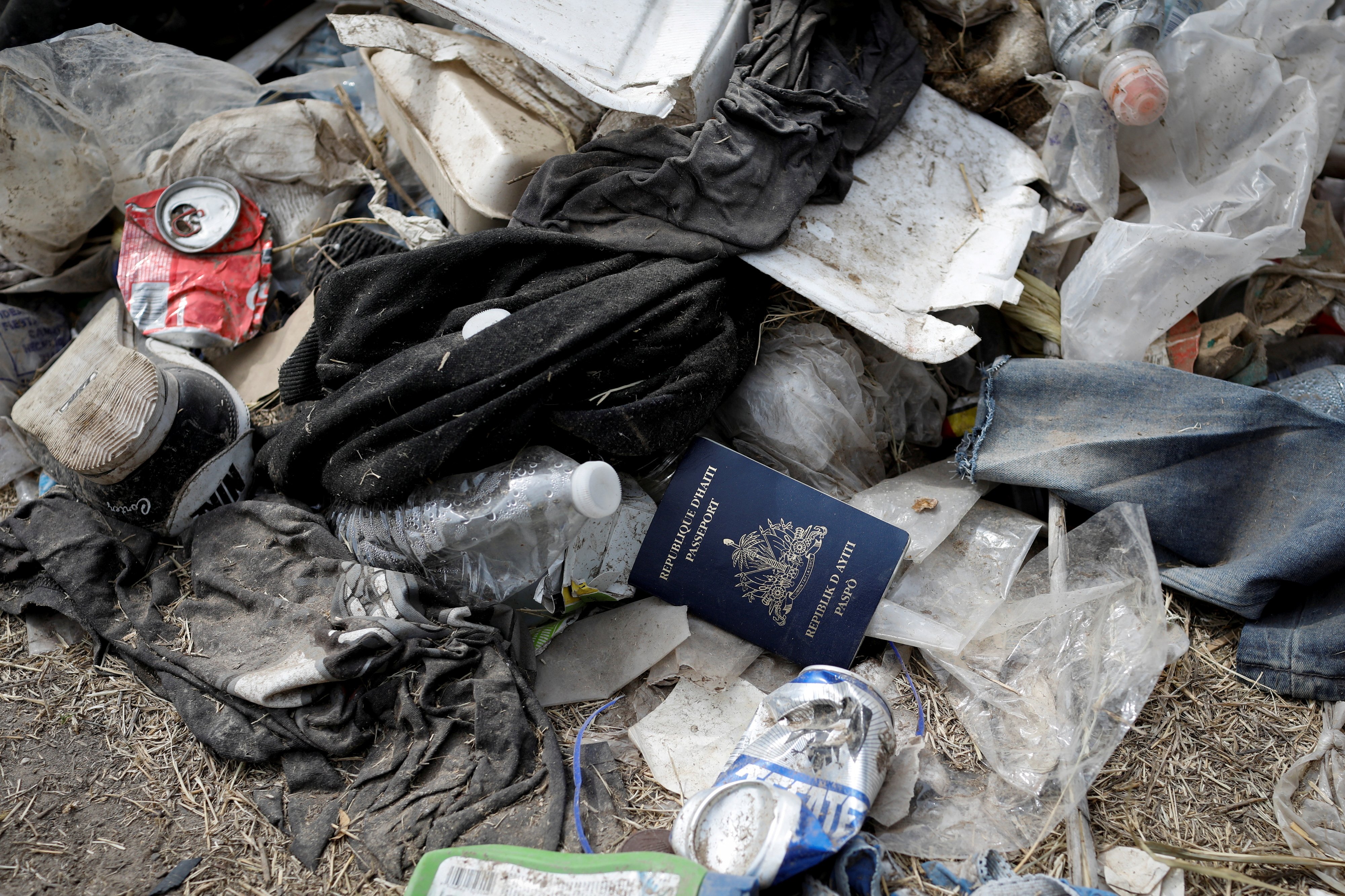 A Haitian passport is seen in a pile of trash Sept. 21, 2021, in Del Rio, Texas, near the International Bridge between Mexico and the United States. (CNS photo/Marco Bello, Reuters)