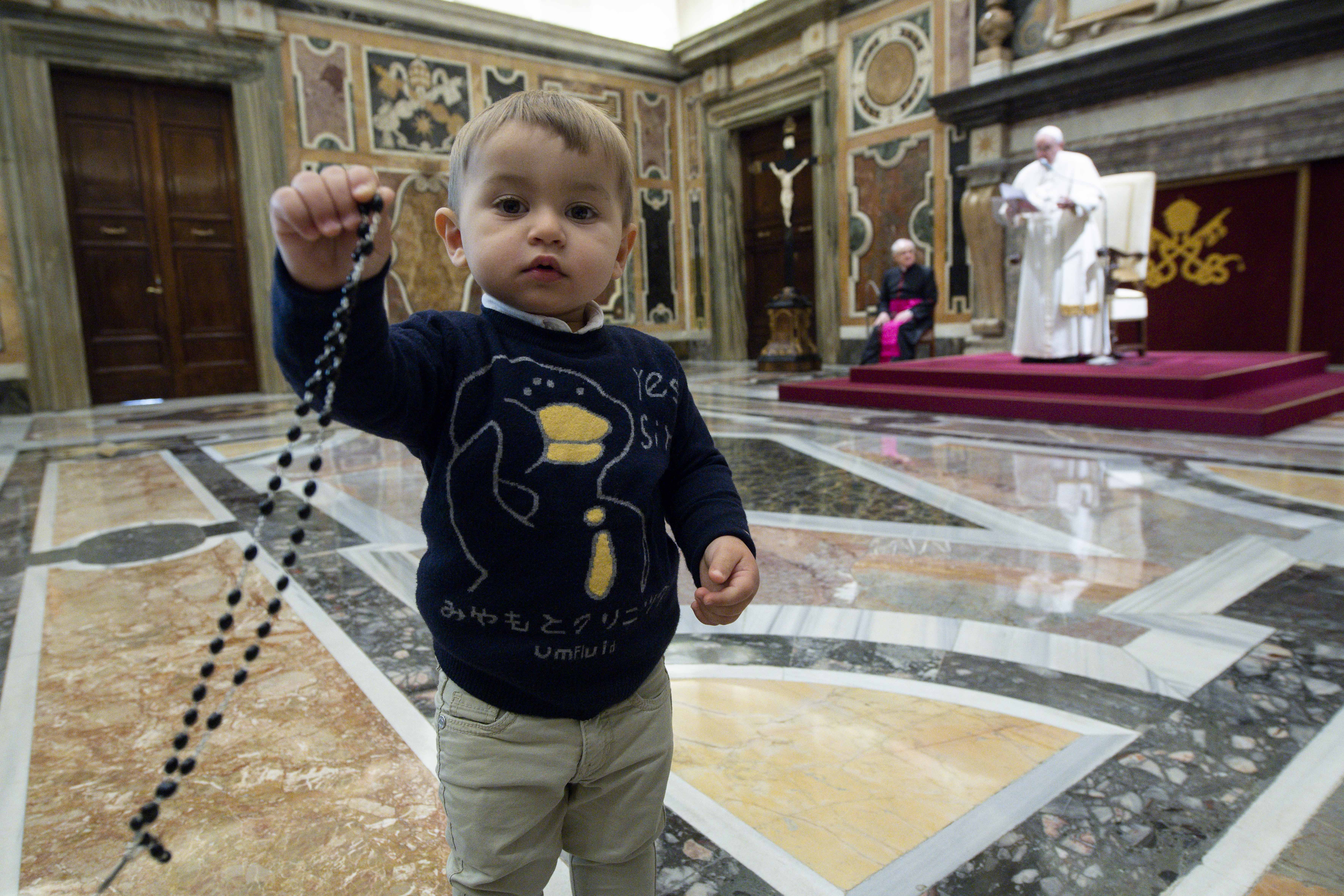 Pope Francis speaks as a boy holds a rosary during a meeting with children from Italy's Catholic Action at the Vatican Dec. 18, 2021. (CNS photo/Vatican Media)