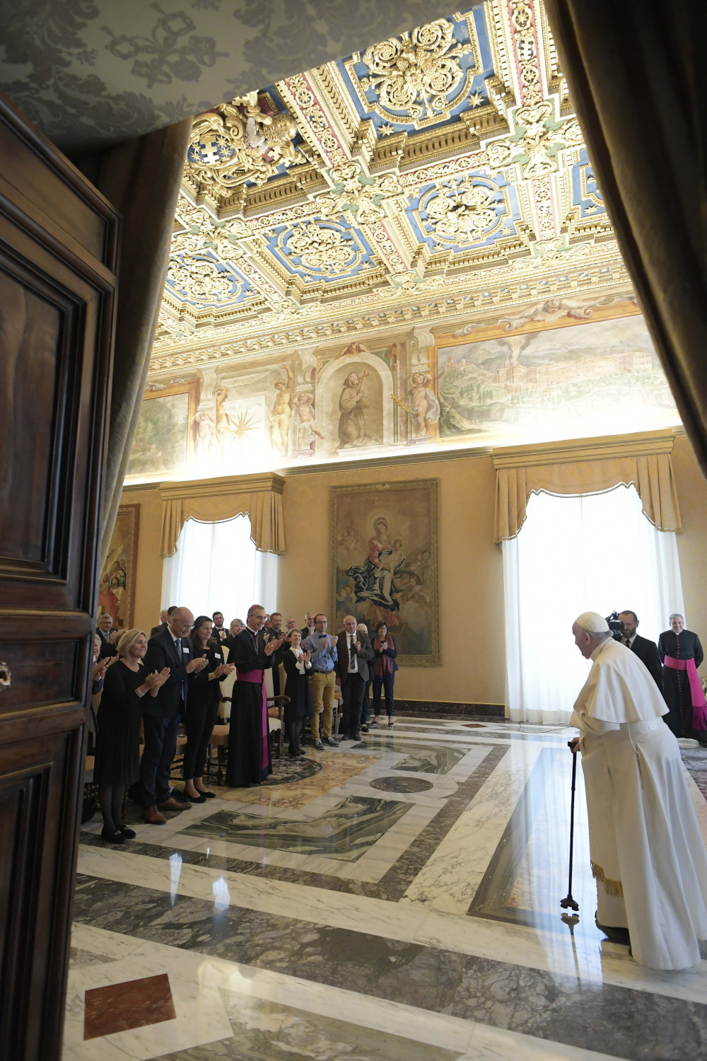 Pope Francis arrives  using a canefor a meeting with elected officials from France 