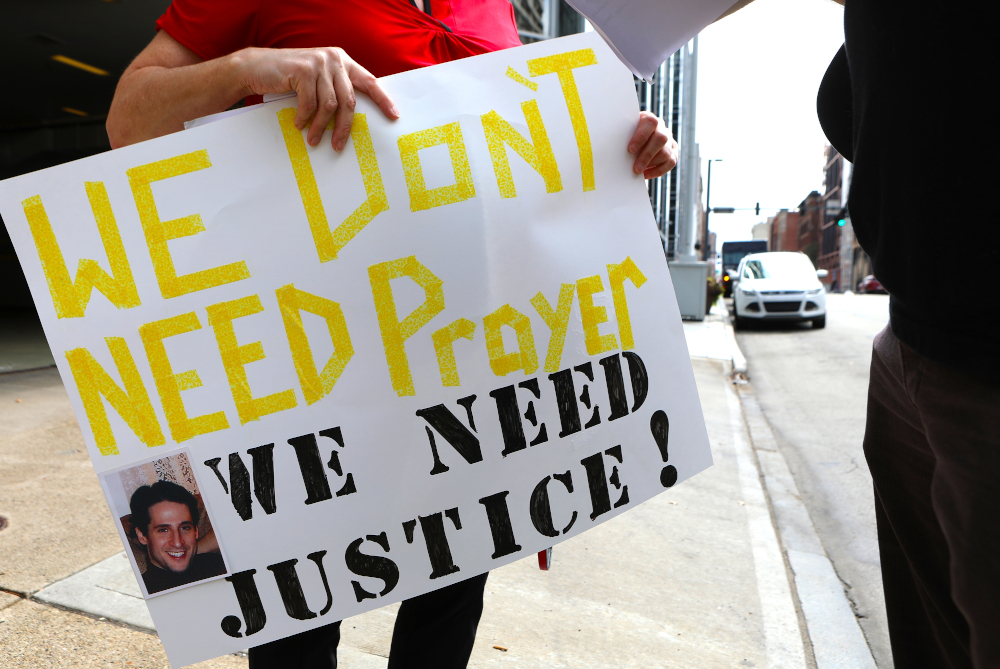 A woman holds this sign as members of the Survivors Network of those Abused by Priests (SNAP) hold a news conference in front of the Diocese of Pittsburgh Aug. 20, 2018, several days after a Pennsylvania grand jury released a stinging report that said more than 300 priests sexually abused more than 1,000 children during the course of several decades. (CNS/Chaz Muth)