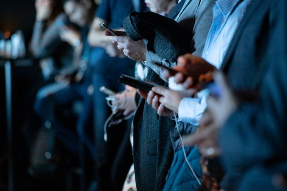 line of people staring at smartphones