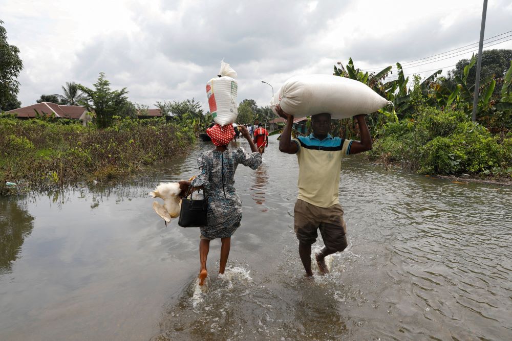 Residents wade through floodwater in Ahoada, Nigeria, Oct. 22, 2022. (CNS/Reuters/Temilade Adelaja)