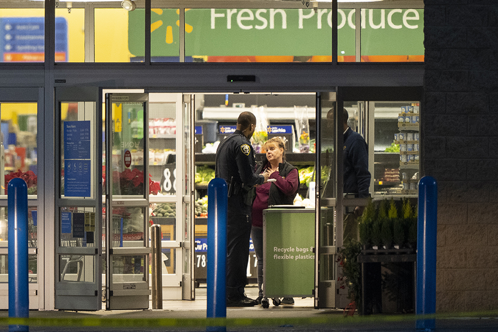 A police officer talks to a female employee at the entrance of a Walmart