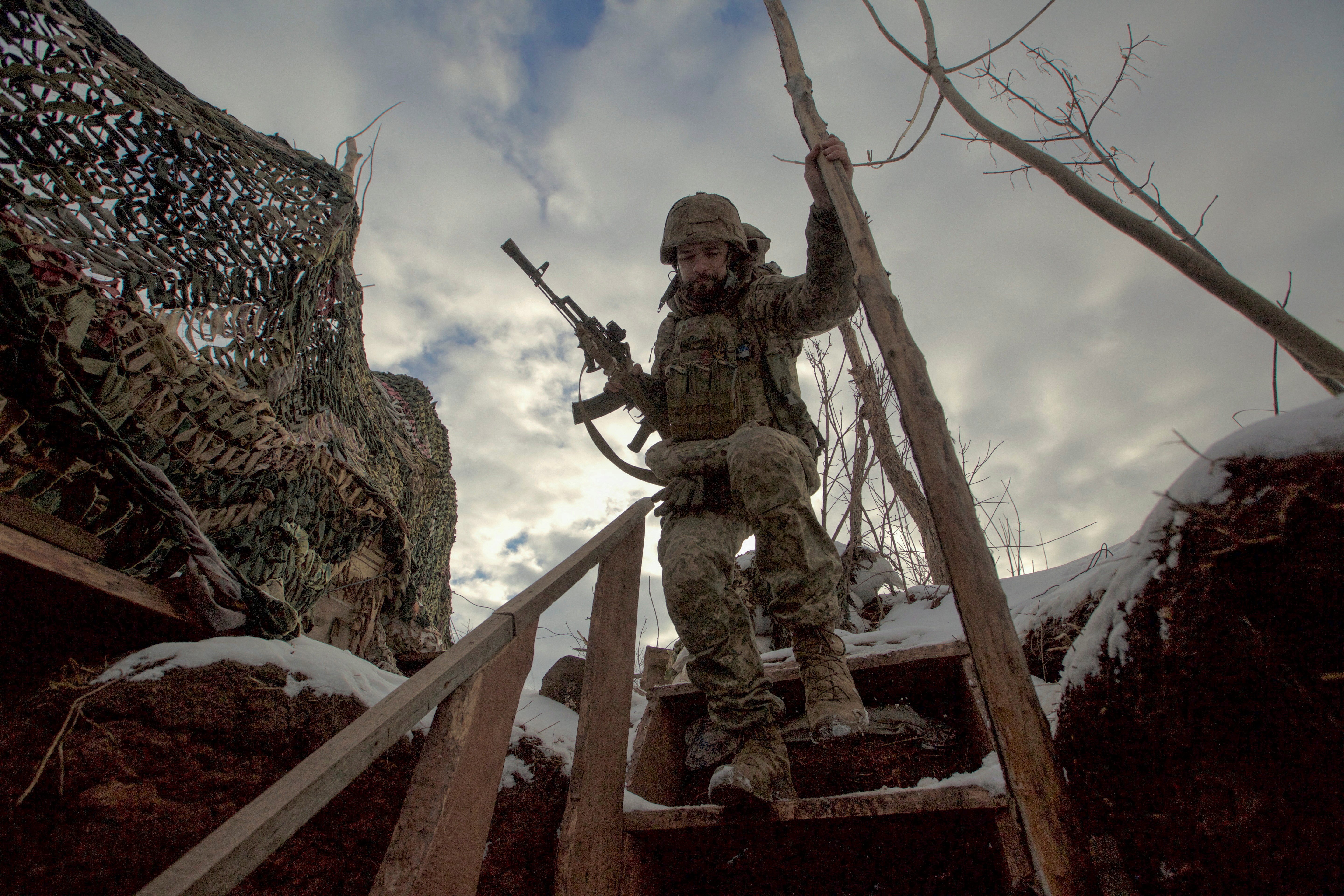 A service member with the Ukrainian armed forces walks past combat positions near a line of separation from Russian-backed rebels near Horlivka in the Donetsk region of Ukraine Jan. 22, 2022. (CNS photo/Anna Kudriavtseva, Reuters)