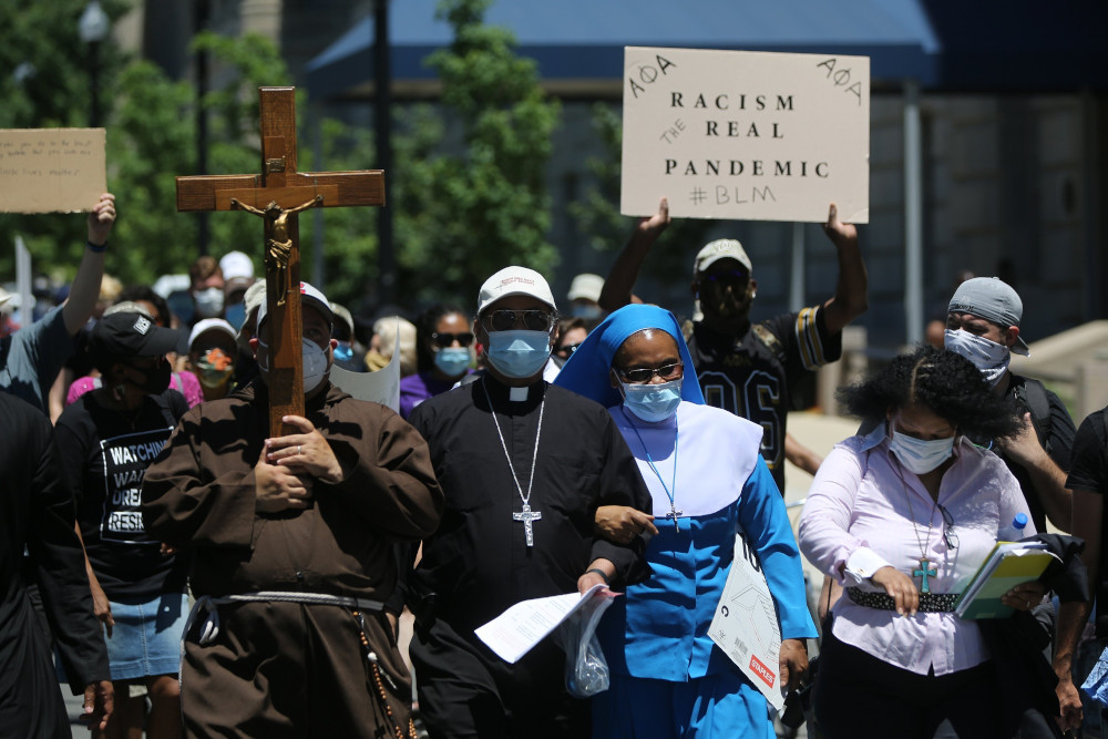 Washington Auxiliary Bishop Roy Campbell and a woman religious walk with others toward the National Museum of African American History and Culture in Washington during an anti-racism protest June 8, 2020. (CNS/Bob Roller)