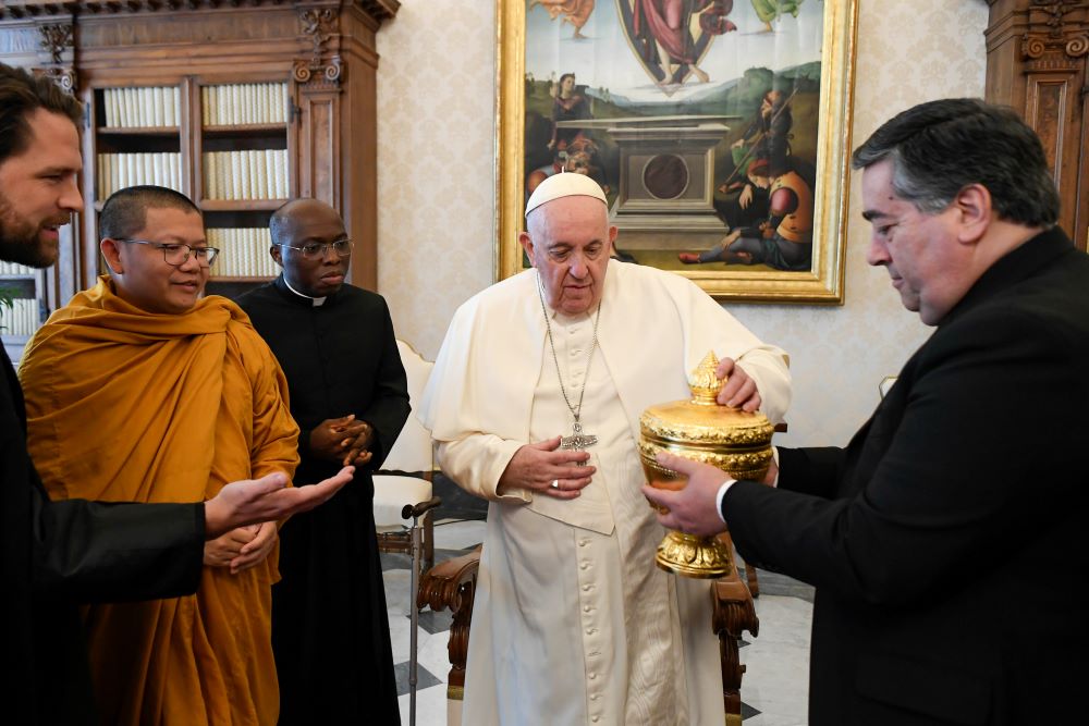 Pope Francis receives a gift from members of a delegation of Buddhists from Cambodia in the library of the Apostolic Palace at the Vatican Jan. 19, 2023. (CNS/Vatican Media)