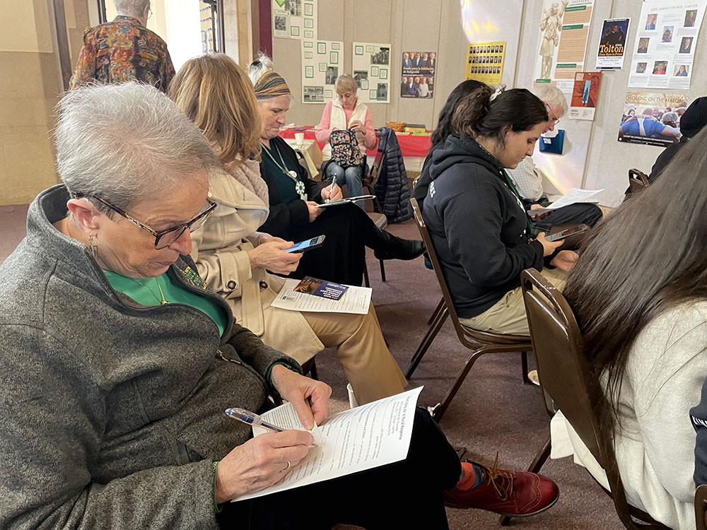 Event attendees, including Detroit Cristo Rey High School students, fill out postcards urging the Environmental Protection Agency to lower allowable soot pollution standards. (Amy Ketner)