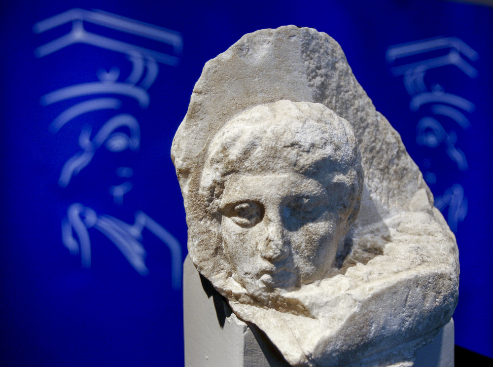 A head is carved on the surface of a white stone