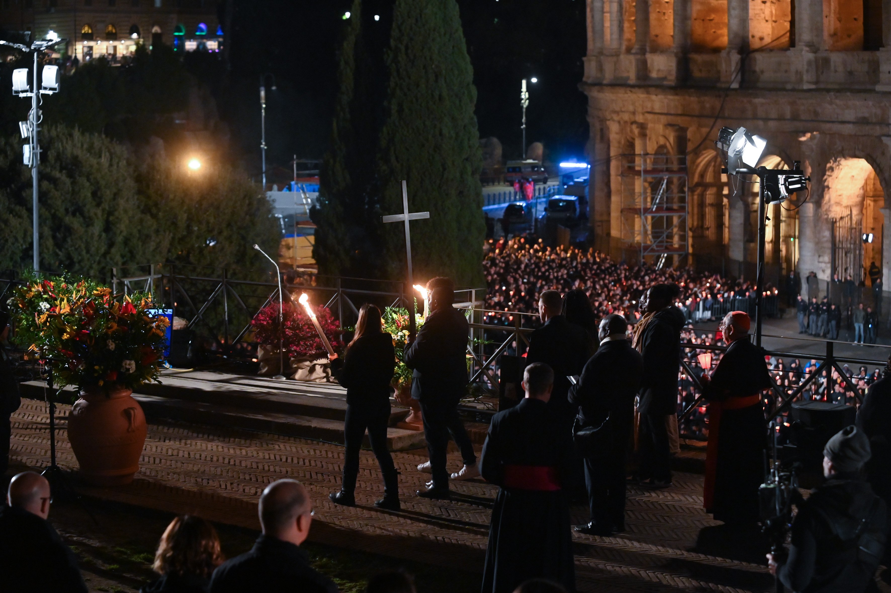 People, including refugees, representing different parts of the world carry the cross in procession as they near the end of the Good Friday Way of the Cross service at Rome's Colosseum April 7, 2023. Pope Francis did not attend the event because of the cold, the Vatican said. (CNS photo/Chris Warde-Jones)