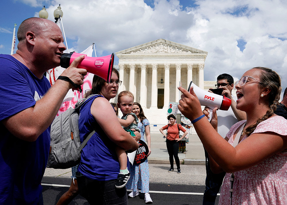 A pro-life activist and a supporter of legal abortion square off with megaphones in front of the U.S. Supreme Court in Washington June 24, 2023, the first anniversary of the court's 2022 ruling in Dobbs v. Jackson Women's Health Organization. (OSV News/Reuters/Evelyn Hockstein)