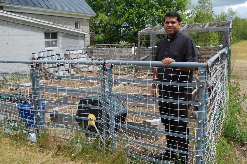 Father Benny Chittilappilly stands in his garden plot in Newport, Vt., May 25, 2023, before planting.