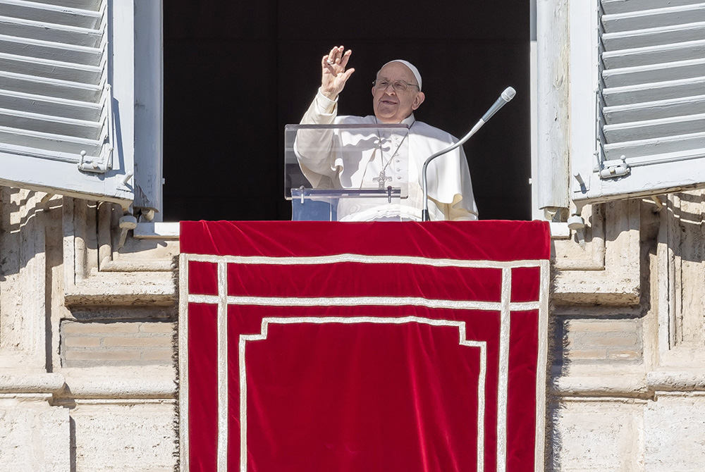 Pope Francis waves to the crowd gathered in St. Peter's Square at the Vatican to pray the Angelus with him Dec. 17. (CNS/Pablo Esparza)