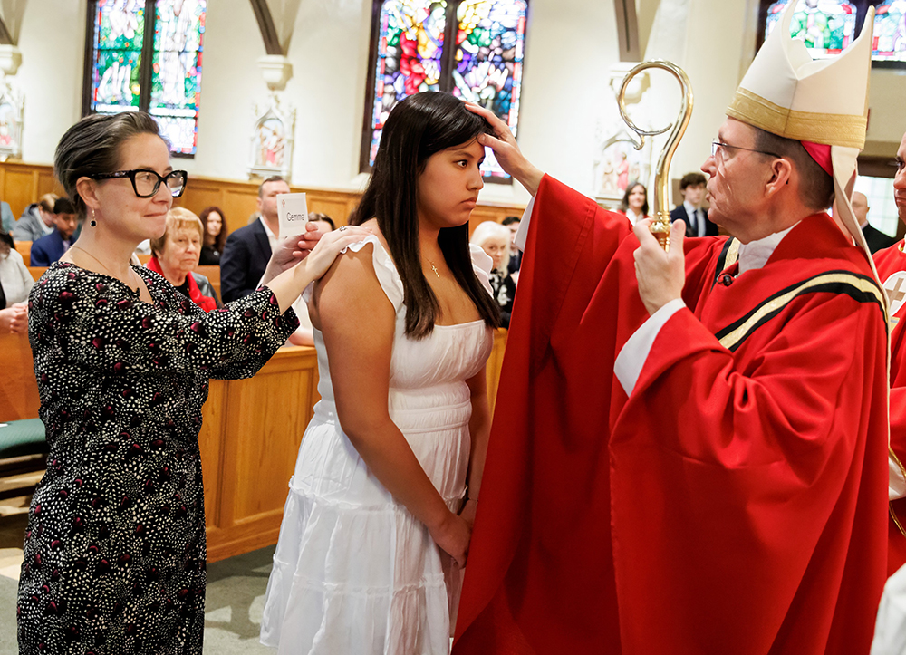 Boston Auxiliary Bishop Robert Reed administers the sacrament of confirmation to a young woman at St. Bridget Church in Framingham, Massachusetts, March 11, 2023. (OSV News/The Pilot//Gregory L. Tracy)