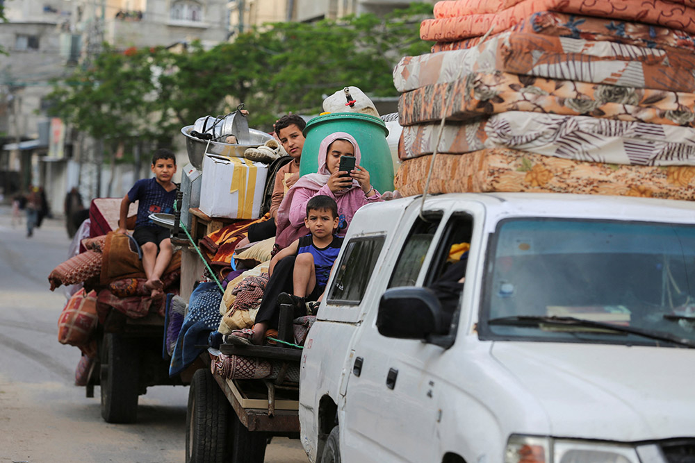 Palestinians travel in vehicles loaded with their belongings as they flee Rafah due to an Israeli military operation in Rafah, in the southern Gaza Strip, May 28, 2024. (OSV News/Reuters/Hatem Khaled)