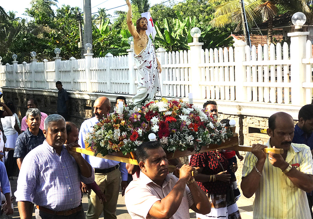 Family members who lost their loved ones during the 2019 Easter bomb attacks carry the bloodstained statue of the risen Christ in the Easter profession March 31 at St. Sebastian's Church in Katuwapitiya, a Negombo suburb in Sri Lanka. (Thomas Scaria)