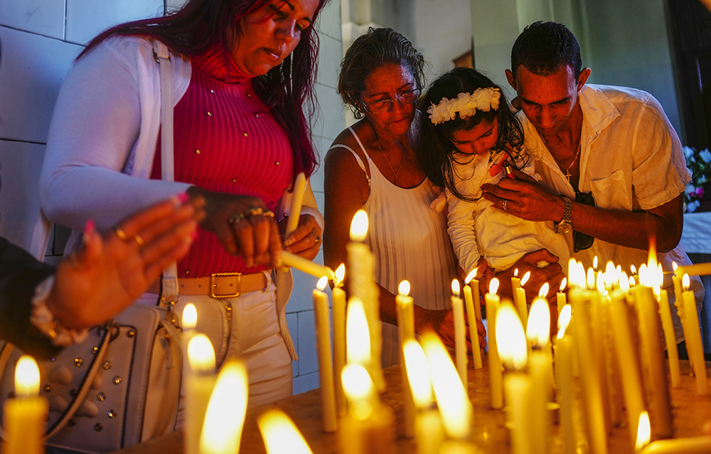 People light candles in honor of Cuba's patron saint, the Virgin of Charity of Cobre, at her shrine in El Cobre, Cuba, Feb. 11, 2024. The Vatican-recognized Virgin, venerated by Catholics and followers of Afro-Cuban Santeria traditions, is at the heart of Cuban identity. (AP/Ramon Espinosa, File)