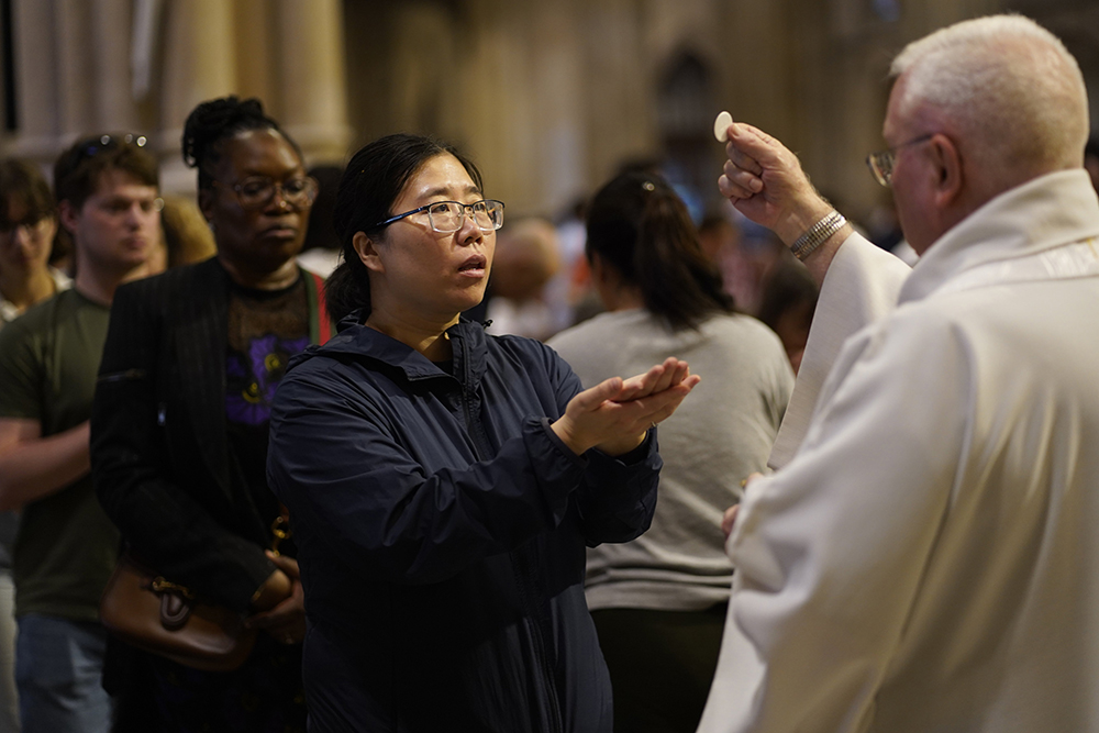 A woman receives Communion during Mass at St. Patrick's Cathedral in New York City May 26, 2024, the solemnity of the Most Holy Trinity. (OSV News/Gregory A. Shemitz)