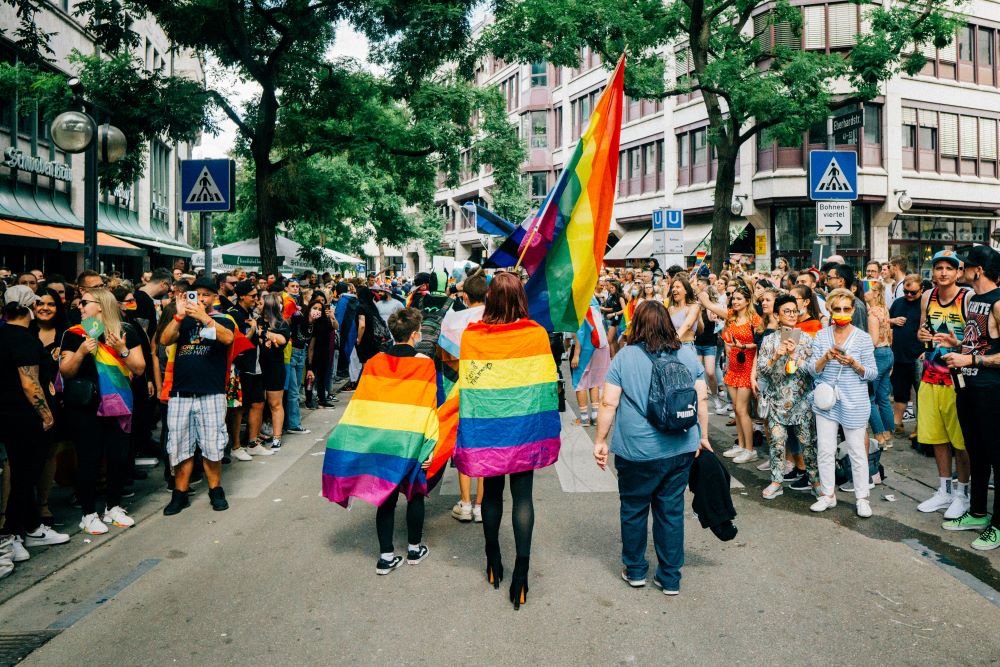 Women wrapped in rainbow flags