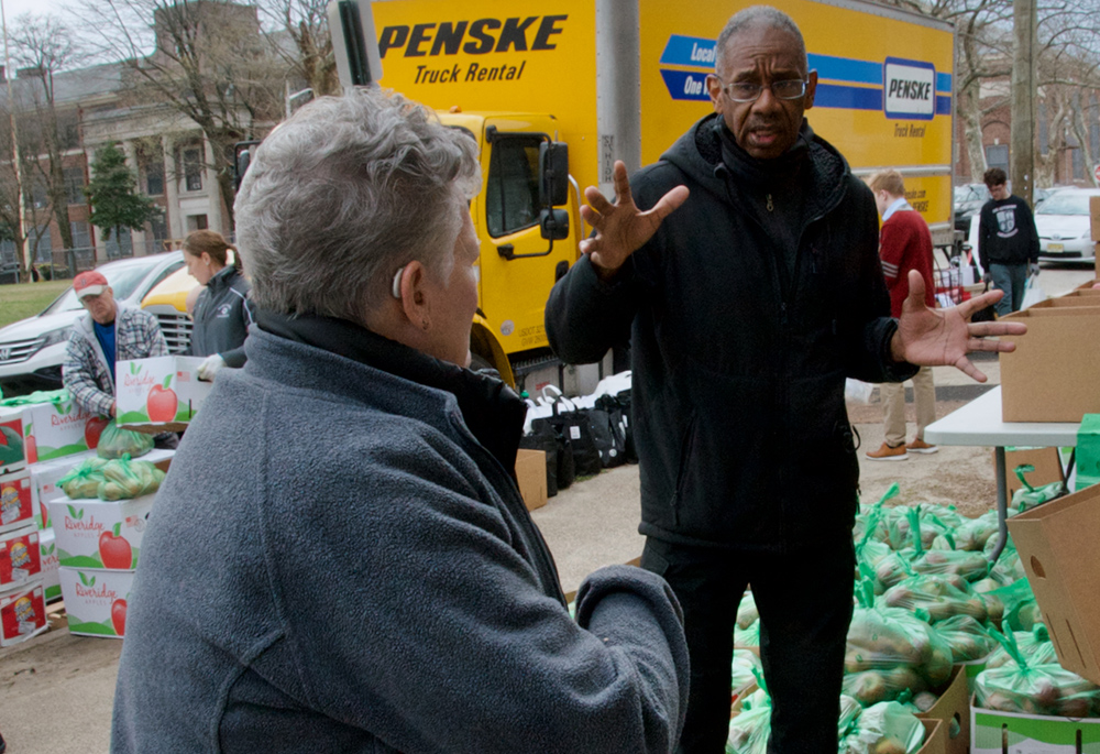 The Rev. Jesse Brown, pastor of Christus Lutheran Church in Camden, New Jersey, speaks with SSJ Neighborhood Center director Sr. Bonnie McMenamin during the center's monthly food distribution day on March 20. (GSR photo/Dan Stockman)