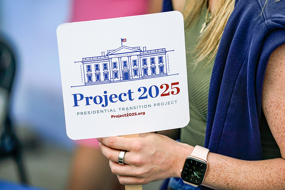 Kristen Eichamer of the Heritage Foundation holds a fan in Project 2025's tent at the Iowa State Fair, Aug. 14, 2023, in Des Moines, Iowa. (AP/Charlie Neibergall)