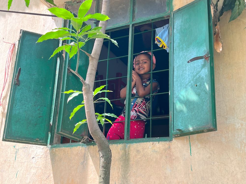 Akhter’s younger daughter, Muntaha, looks out a window. (Grist/Mahadi Al Hasnat)