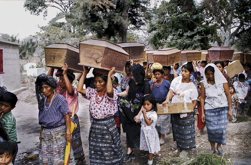 Maya Ixil people carry caskets to bury the remains of loved ones slain during the 36-year long Guatemalan civil war. Since 1996, the Foundation for Forensic Anthropology of Guatemala has taken samples from family members and bones of the deceased, collecting DNA material from 18,000 family members and 10,000 of the dead into the foundation's gene bank. (Berlin Juarez)