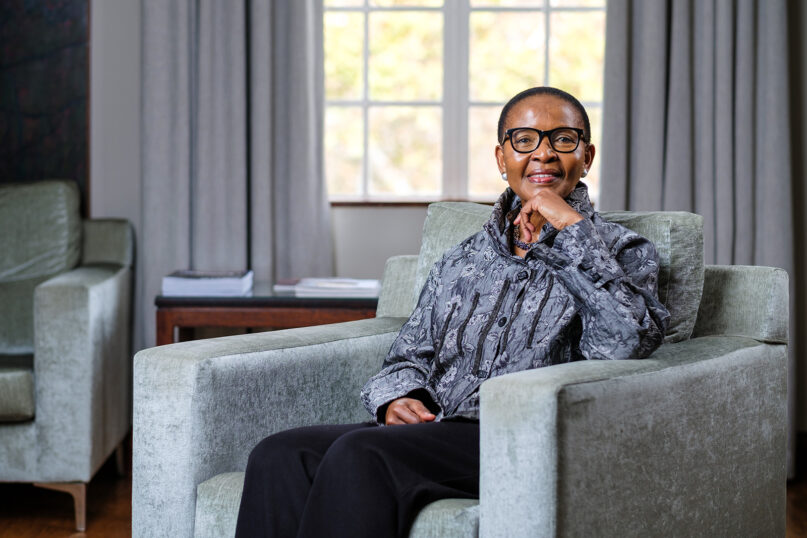 Pumla Gobodo-Madikizela sits in a chair smiling at camera