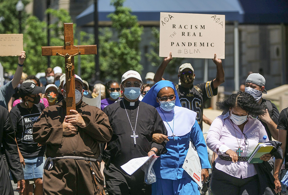 Washington Auxiliary Bishop Roy Campbell and a woman religious walk with others toward the National Museum of African American History and Culture in Washington during an anti-racism protest June 8, 2020. (CNS/Bob Roller)