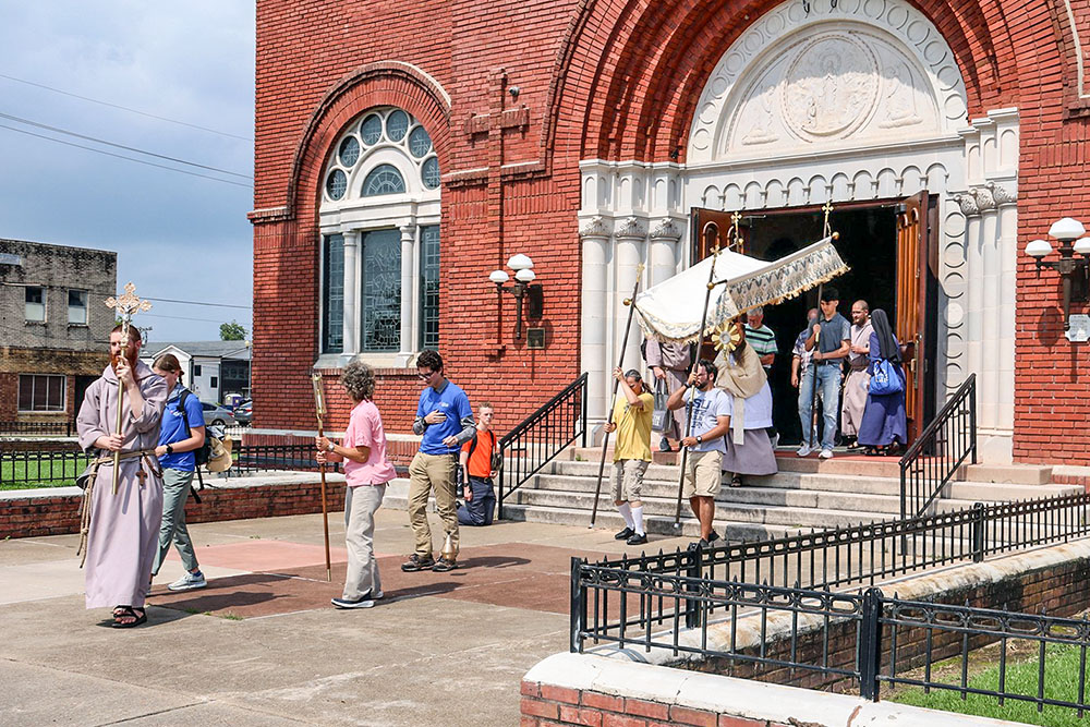 Following midday prayer and adoration June 4 at the Cathedral of the Immaculate Conception in Lake Charles, Louisiana, pilgrims on the southern Juan Diego Route of the National Eucharistic Pilgrimage process out of the cathedral to continue with the Eucharist to the offices of Catholic Charities of Southwest Louisiana, where pilgrims helped load food baskets to be given to locals in need. (OSV News/Courtesy of Lake Charles Diocese/Morris Lebleu)