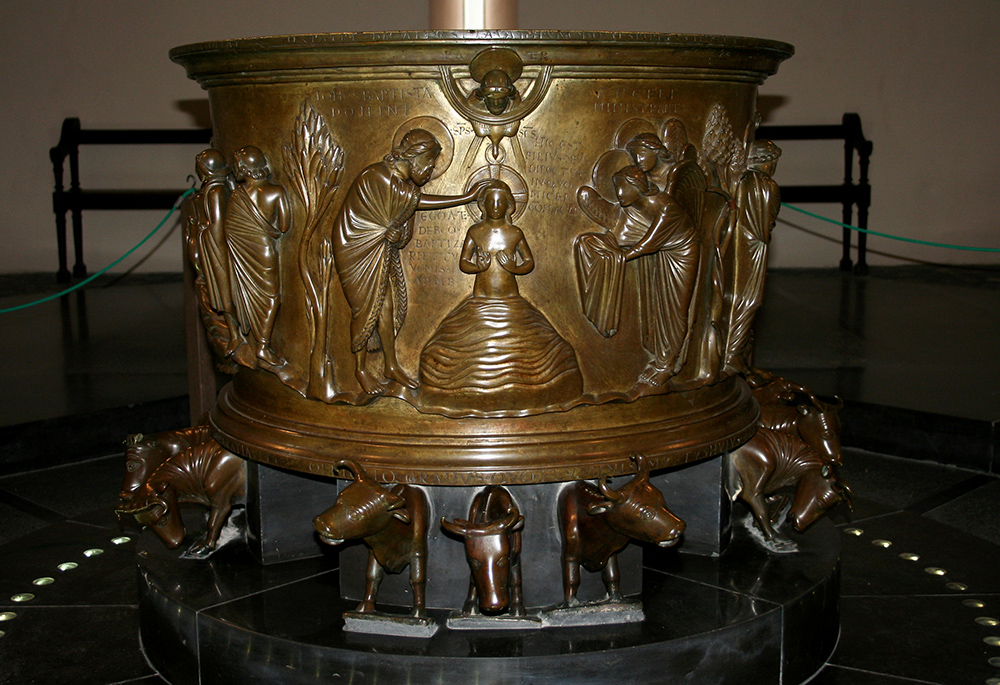 The Baptismal font of St. Bartholomew Church in Liège, Belgium, carries the imagery of golden calves forward. Twelve bulls support the basin, where Christ stands in the waters of the Jordan, the power of the Holy Spirit rushing upon him (1 Samuel 16:13). (Wikimedia Commons/Jean-Pol Grandmont, CC by 2.5)