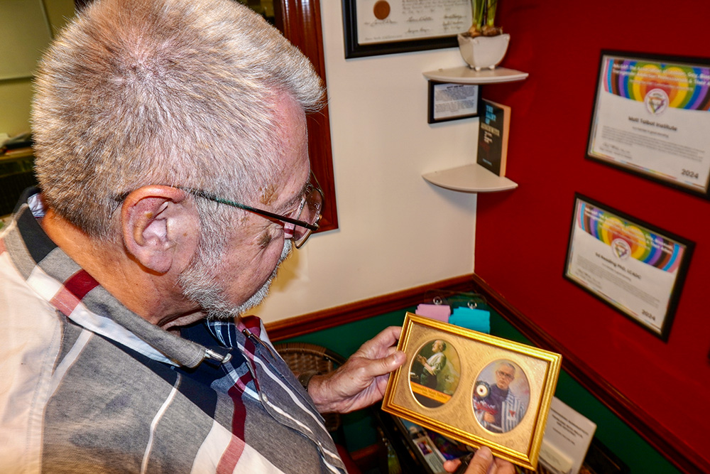 Fr. Ed Reading in his studio in July holds icons of St. Maximilian Kolbe and Venerable Matt Talbot, protectors of recovering addicts. (Camillo Barone)