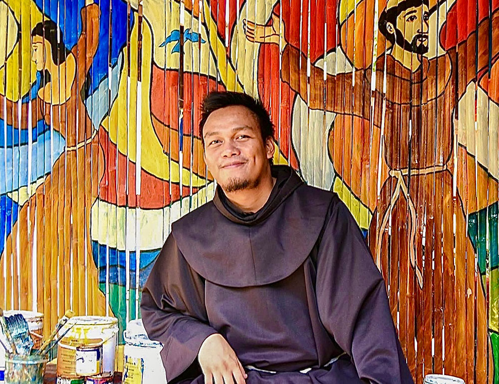 Franciscan Br. Christopher Villanueva of the Philippines in front of one of his artworks (Courtesy of Order of Friars Minor)