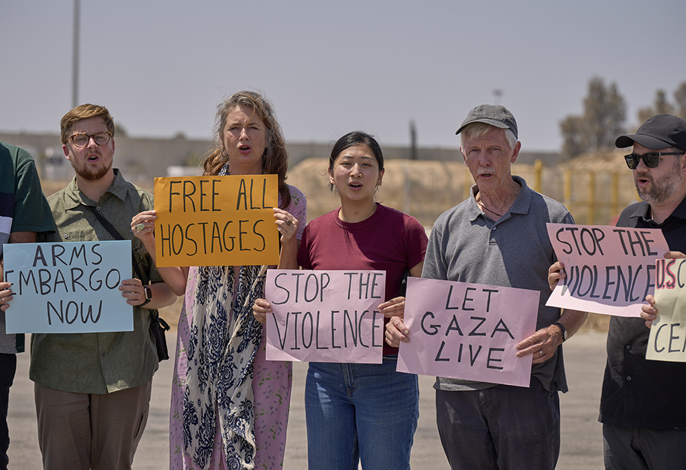 A delegation of U.S. Christians holds a prayer vigil Aug. 18 at the Kerem Shalom crossing on the border between Israel and Gaza. "Amidst the tension, distrust and trauma, Jesus' way of courageous nonviolence offers a path to break the cycle of violence and cultivate a just peace for all people," said participant Eli McCarthy, a teacher at Georgetown University and expert in nonviolence and restorative justice. (Life on Earth Pictures/Paul Jeffrey)