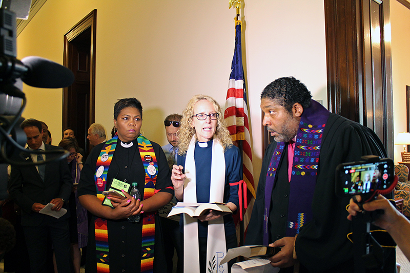 Butler seen with other faith leaders in corridor. 