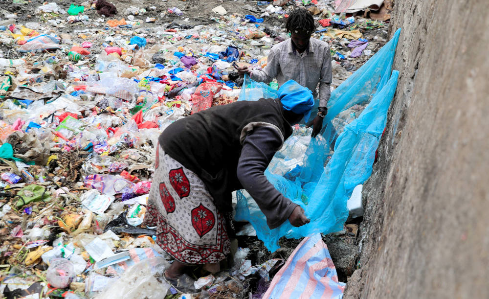 A woman uses a net to sort recyclable plastic materials from a dumping site in Nairobi, Kenya, Feb. 1, 2022. (CNS photo/Thomas Mukoya, Reuters)