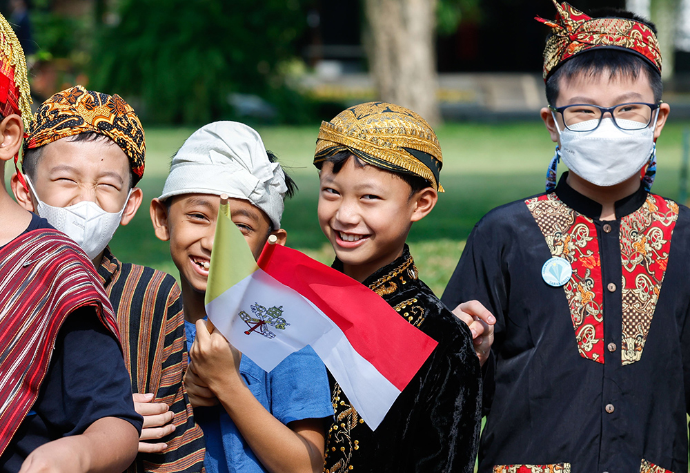 A group of children smile as they wait for Pope Francis to attend an official welcome ceremony outside Merdeka Palace in Jakarta, Indonesia, on Sept. 4. (CNS/Lola Gomez)